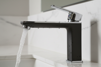 Premium matte black bathroom faucet with flowing water on white marble background — plumbKart
